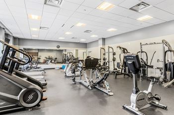 a gym filled with cardio equipment and weights